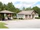 Exterior view of the clubhouse with a pool gazebo, nestled among lush trees at 594 Executive Dr, Lillington, NC 27546