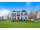 Two-story home features a manicured lawn, neutral siding, and a covered front porch at 594 Executive Dr, Lillington, NC 27546