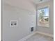 Laundry room with upper shelving, tile flooring, window, and utility connections at 594 Executive Dr, Lillington, NC 27546
