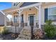 Inviting front porch with stone accents, dark railings, and a covered entrance at 594 Executive Dr, Lillington, NC 27546