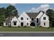 Magnificent new construction home exhibiting light brick and white siding, complemented by lush landscaping and a manicured lawn at 6500 Century Oak Ct, Raleigh, NC 27613