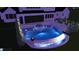 Night view of a stunning pool featuring a unique water feature, integrated spa, and elegant lounging area in backyard setting at 6500 Century Oak Ct, Raleigh, NC 27613