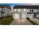 Exterior shot of modern townhomes showing gray siding, two-car garage and an inviting facade at dusk at 945 Alma Railway Dr # 559, Wake Forest, NC 27587