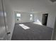 Bright, carpeted bedroom with abundant natural light from two windows and ample closet space at 1021 Prominence Dr., Homesite 20, Durham, NC 27712