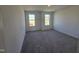 Cozy bedroom featuring plush carpeting, neutral wall colors, and a pair of bright windows at 1021 Prominence Dr., Homesite 20, Durham, NC 27712