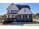 Charming two-story home with a covered porch and stone accents at 1021 Prominence Dr., Homesite 20, Durham, NC 27712