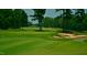 Lush green golf course with sand traps and a red flag on the green at 1021 Prominence Dr., Homesite 20, Durham, NC 27712