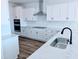 Modern kitchen with stainless steel appliances, quartz countertops, and white cabinets at 1021 Prominence Dr., Homesite 20, Durham, NC 27712