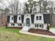 Charming two-story home featuring a symmetrical facade, black roof, and white brick exterior at 109 Chatterson Dr, Raleigh, NC 27615