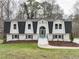 Charming two-story home featuring a symmetrical facade, black roof, and white brick exterior at 109 Chatterson Dr, Raleigh, NC 27615