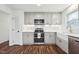 Renovated kitchen boasts grey cabinets, stainless appliances, and modern farmhouse sink at 109 Chatterson Dr, Raleigh, NC 27615
