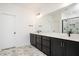 Modern bathroom featuring double vanity, black hardware, and marble tile floors at 1205 Porters Call Dr, Wendell, NC 27591