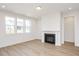 Cozy living room with a classic fireplace and ample natural light from large windows at 1205 Porters Call Dr, Wendell, NC 27591