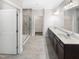 Bright, tiled bathroom boasts double sinks, a glass shower, and an open doorway to a walk-in closet at 154 Magenta Rose Dr, Raleigh, NC 27610