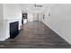 Open-concept living room with a fireplace, ceiling fan, dark wood floors, and bright neutral paint at 154 Magenta Rose Dr, Raleigh, NC 27610
