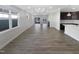 Open concept living room with wood flooring, large windows, and access to the kitchen and outdoor space at 154 Magenta Rose Dr, Raleigh, NC 27610
