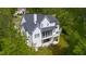 An aerial view of a farmhouse style home with a screened porch and balcony set among mature trees at 175 Stonecrest Way, Pittsboro, NC 27312