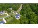 Aerial shot of a neighborhood home surrounded by mature trees with winding streets at 175 Stonecrest Way, Pittsboro, NC 27312