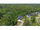 Aerial shot of a neighborhood home surrounded by mature trees with a winding driveway and landscaping at 175 Stonecrest Way, Pittsboro, NC 27312