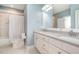 Light-filled bathroom with double vanity, marble floors, quartz countertop, tub-shower combo, and soft blue walls at 175 Stonecrest Way, Pittsboro, NC 27312