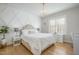 Cozy bedroom with decorative accent wall, a crystal chandelier and light wood floors at 175 Stonecrest Way, Pittsboro, NC 27312