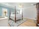 Spacious bedroom with a chandelier, light blue walls, hardwood floors, and a decorative rug at 175 Stonecrest Way, Pittsboro, NC 27312