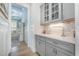 Butler's pantry with grey cabinets, marble backsplash and countertops and glass door cabinets at 175 Stonecrest Way, Pittsboro, NC 27312