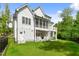 Expansive view of a white farmhouse-style home with a screened porch, balcony and lawn at 175 Stonecrest Way, Pittsboro, NC 27312