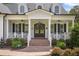 Inviting front porch with brick steps, double doors, white railings, and beautiful landscaping at 175 Stonecrest Way, Pittsboro, NC 27312