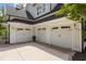 Spacious three-car garage with white doors, black hardware, and a stylish black metal roof at 175 Stonecrest Way, Pittsboro, NC 27312