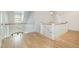 Upstairs hallway with wood floors, white walls, and natural light coming through a window at 175 Stonecrest Way, Pittsboro, NC 27312