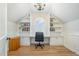 Bright home office with built-in shelves, hardwood floors, a modern desk and chair and a decorative chandelier at 175 Stonecrest Way, Pittsboro, NC 27312