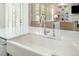 Farmhouse kitchen sink with white countertops, woven barstools, and shuttered windows at 175 Stonecrest Way, Pittsboro, NC 27312