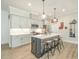Stylish kitchen with an island with seating, stainless steel appliances, white countertops, and modern lighting at 175 Stonecrest Way, Pittsboro, NC 27312