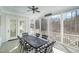 Relaxing screened-in porch with a ceiling fan and a dining table with black and white chairs at 175 Stonecrest Way, Pittsboro, NC 27312
