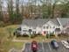 Aerial view featuring a townhome community with parking and sidewalks, nestled among tall trees and lush greenery at 2268 Plum Frost Dr, Raleigh, NC 27603