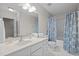 Bright bathroom features a shower-tub combo with patterned blue curtain and spacious vanity at 2268 Plum Frost Dr, Raleigh, NC 27603