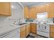 Traditional kitchen with wood cabinets, white appliances, and laminate flooring at 2268 Plum Frost Dr, Raleigh, NC 27603
