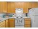 Traditional kitchen features wood cabinets and updated white appliances at 2268 Plum Frost Dr, Raleigh, NC 27603