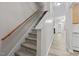 Carpeted stairs with wooden handrail leading into an open-concept home at 2268 Plum Frost Dr, Raleigh, NC 27603