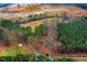 An aerial view showcases a home surrounded by lush trees, with a development site in the distance at 2502 Devils Racetrack Rd, Four Oaks, NC 27524
