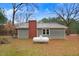 Charming home with green siding, brick chimney, and a propane tank in the front yard at 2502 Devils Racetrack Rd, Four Oaks, NC 27524