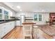 This kitchen offers white cabinets, wood floors, island with seating, and an easy flow into a cozy living space at 2502 Devils Racetrack Rd, Four Oaks, NC 27524