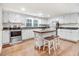 Bright kitchen features stainless steel appliances, white cabinets, wood floors, and a center island with seating at 2502 Devils Racetrack Rd, Four Oaks, NC 27524