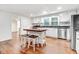 Kitchen with island seating, stainless appliances, white cabinets and hardwood floors creates an inviting space at 2502 Devils Racetrack Rd, Four Oaks, NC 27524
