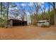 A gravel driveway leads to an outbuilding on a spacious lot surrounded by mature trees at 2502 Devils Racetrack Rd, Four Oaks, NC 27524