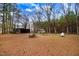 A view of an expansive lot with mature trees, a small outbuilding and a gravel driveway at 2502 Devils Racetrack Rd, Four Oaks, NC 27524