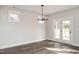 Well-lit living room with wood floors, a modern chandelier, and glass doors to the outside at 264 Big Bradley Dr, Wendell, NC 27591