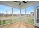 A screened porch features a wooden floor, white railings, and views of neighborhood homes at 264 Big Bradley Dr, Wendell, NC 27591