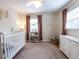 Charming Bedroom with a white crib, dresser, and soft pink accents under natural light at 304 Northbrook Dr, Raleigh, NC 27609